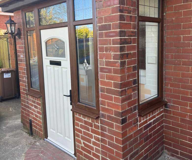 A completed brick porch with a white front door and classic wooden-framed windows.