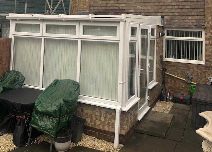 Older Northumberland conservatory with polycarbonate roof before tiled roof replacement for improved energy efficiency