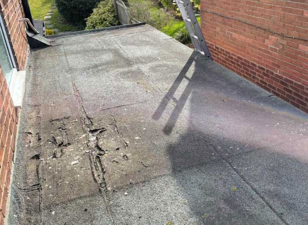 Worn and cracked felt flat roof showing visible ageing before repair work in Washington