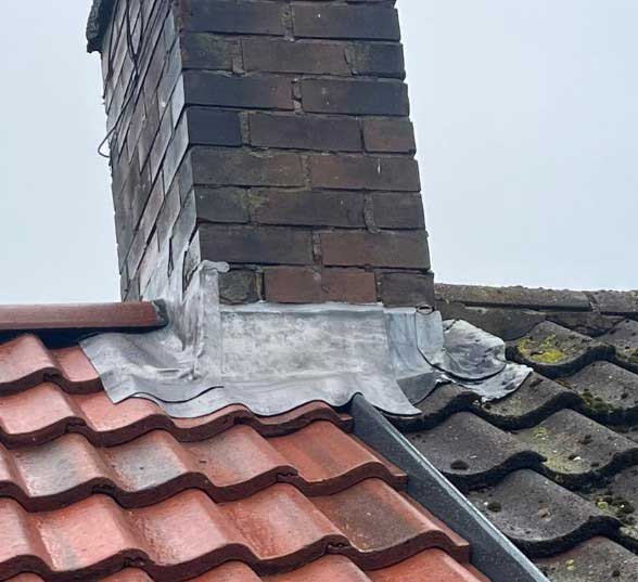 Repairing damaged lead flashing around a chimney base to prevent leaks and protect the roofline on a Gateshead home.