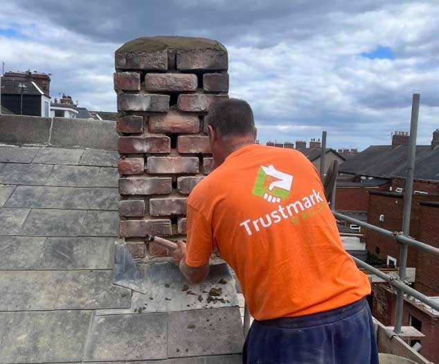 Repointing worn mortar joints on a brick chimney stack in Gateshead to improve stability and stop water ingress.