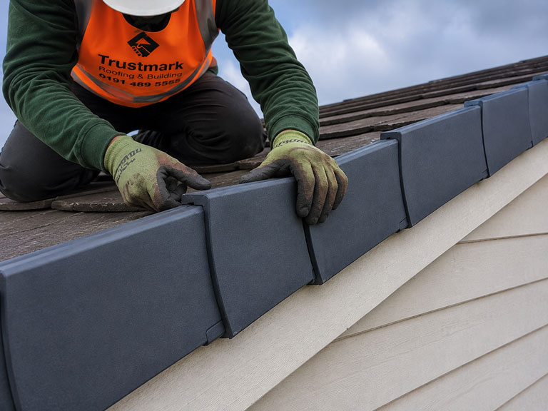 Roofer repairing loose dry verge units on a Gateshead house